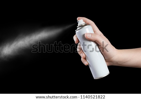 Hand using a spray, isolated on black background