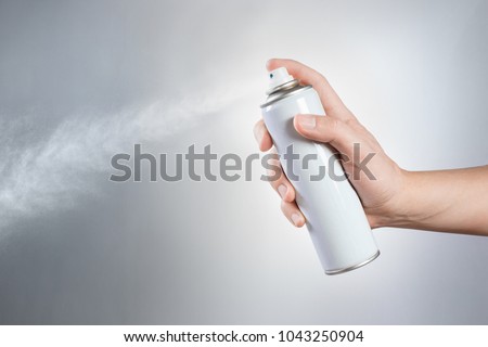 Hand using a spray on white background