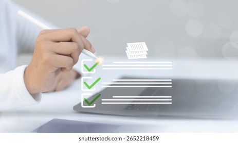 Hand using a stylus to check a digital checklist on a laptop, representing task management, project planning, productivity, and digital to-do list solutions.