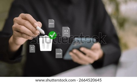 Hand using stylus to delete error files on smartphone, concept of digital cleanup, storage optimization, and error fixing.