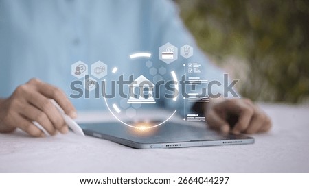 Hand using stylus on tablet with bank icon, representing digital banking, online financial transactions, and fintech innovation services.