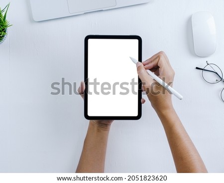 hand using stylus pen on mini digital tablet on white table background