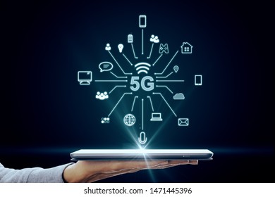 Hand using tablet with abstract 5G interface with computing icons on dark background. Internet speed and ai concept