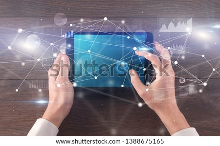 Hand using tablet with linking graphs charts  report and informational flow concept