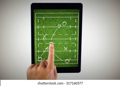 Hand using tablet pc against rugby tactics