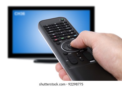 Hand Using Tv Remote Control To Change Channels On Defocused Television In The Background