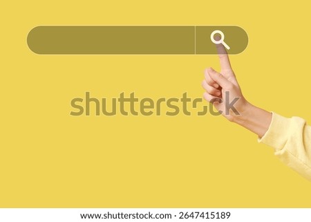Hand using web search engine on yellow background