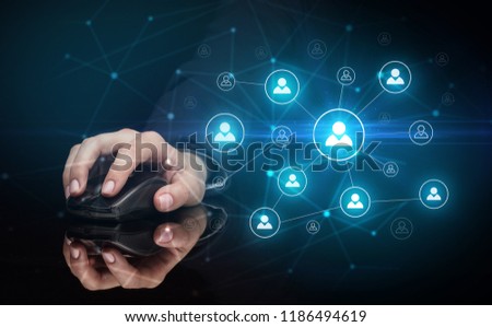 Hand using wireless mouse in a dark environment with human network concept