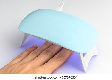 Hand In UV Lamp Lights For Nails On A White Background.