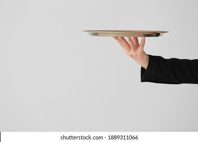 Hand Of Waiter With Empty Tray On Grey Background