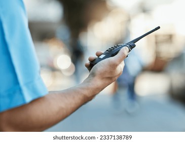 Hand, walkie talkie and a security guard or safety officer outdoor on a city road for communication. Closeup of person with a radio on urban street to report crime for investigation and surveillance