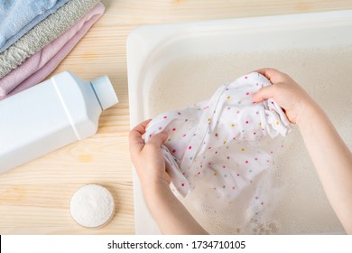 
Hand Wash Baby Clothes, Washing Powder, Plastic Box For Washing On A Wooden Table