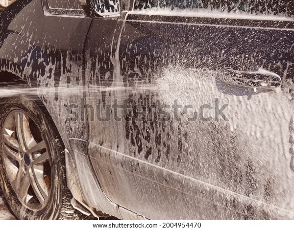 Hand wash the car with water and shampoo,\
the water jet is directed at the car\
side