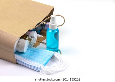 Hand Washes Alcohol, Gel, Medical Mask, And Medicine In A Brown Paper Bag On White Background.