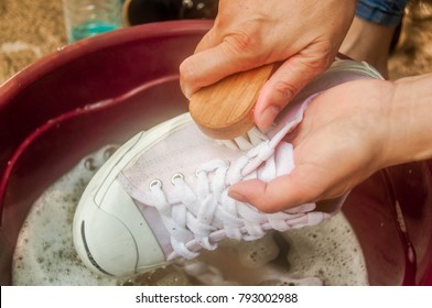 The Hand Washing A Dirty White Shoes At Home