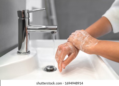 Hand Washing Lather Soap Rubbing Wrists Handwash Step Woman Rinsing In Water At Bathroom Faucet Sink. Wash Hands For COVID-19 Spreading Prevention. Coronavirus Pandemic Outbreak.