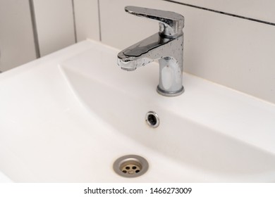 Hand washing. White ceramic sink and bathroom faucet
