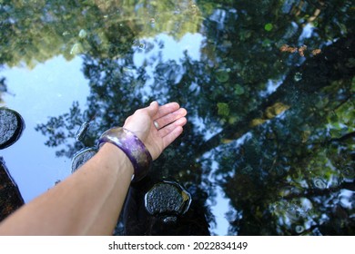 Hand In Water. Scenic View Of The Neon Blue Waters Of A Karst Spring, Spring (outflow Of Groundwater) That Is Part Of A Karst Hydrological System. Blue Springs In Tomaszow Mazowiecki, Poland, Europe