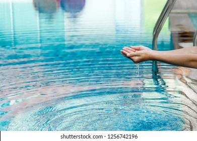 Hand and water touch the blue water. To refresh the concept of playing clean water with copy space. - Shutterstock ID 1256742196