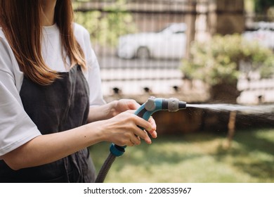 Hand Watering The Lawn Near The Flower Shop. Close-up Photo