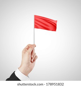 Hand Waving A Red Flag Isolated On White Background