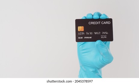 Hand Wear Blue Medical Glove Holding Black Credit Card On White Background.