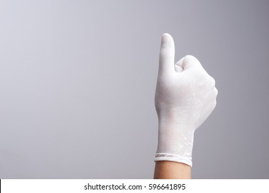 Hand Wearing Latex Glove With Thumb Up Gesture On White Background