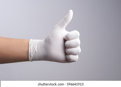 Hand Wearing Latex Glove With Thumb Up Gesture On White Background