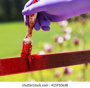 Hand wearing purple gloves and painting with a paint brush. - Powered by Shutterstock