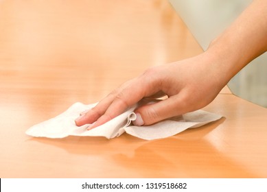 hand with wet wipe cleaning table - Shutterstock ID 1319518682