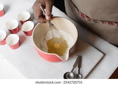 Hand Whisking Vanilla ingredients for making cupcake batter in a red mixing bowl, process of making cupcakes - Powered by Shutterstock