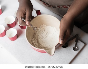 Hand Whisking Vanilla ingredients for making cupcake batter in a red mixing bowl, process of making cupcakes - Powered by Shutterstock