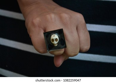a hand wielded with a skull ring