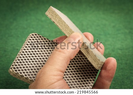 Hand wiht Deck of Cards on Green
