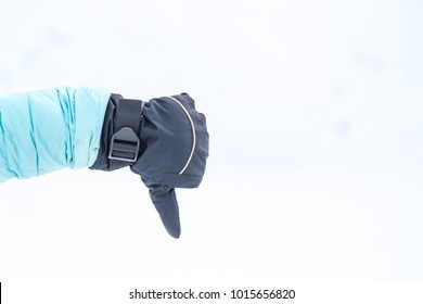 Hand In Winter Glove Gesture Dislike Or Thumb Down On Snowly Background