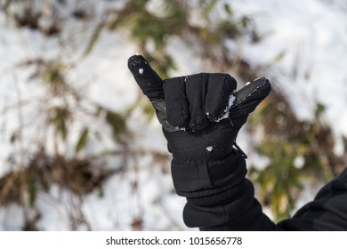 Hand In Winter Glove Gesture Number Six On Snowy Background