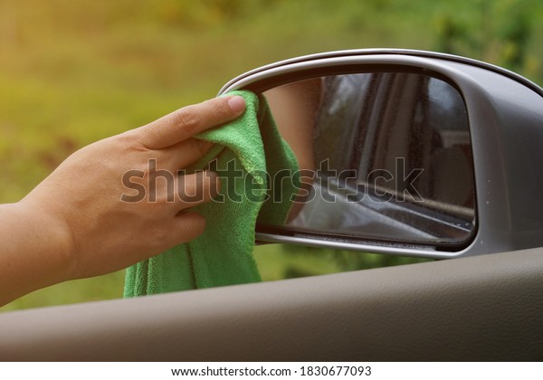 The hand is wipes\
the car side mirror cleaner to clean it up to make the reflection\
more clearly.\
The concept vehicle condition monitoring for\
increased safety in use.