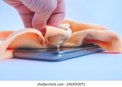 Hand Wiping The Phone With Microfiber Cloth.