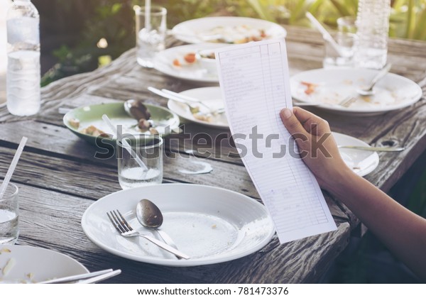 Hand of woman asia Check bill . Pay for food after\
eating out .