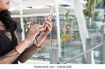 Hand of woman in black dress holding sunglasses and touching mobile phone screen with modern style office background. Lifestyle, trendy fashion, and smartphone addict, social media - Shutterstock ID 1181661208