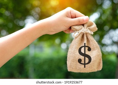 Hand Of A Woman Carrying A Purse Money .concept Saving Money And Investment Concept