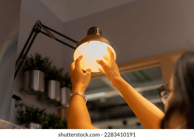 Hand woman changing with new LED lamp light bulb,Power saving concept. Reusing and recycling existing materials for future growth of business and environment sustainable. 