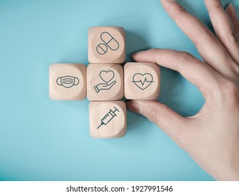 Hand woman choose wood cube stacking with icon healthcare medical on blue background, Health Insurance Concept - Powered by Shutterstock