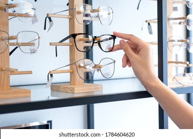 Hand of  woman choosing the glasses in optics store, eyesight and vision concept  - Shutterstock ID 1784604620