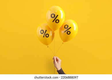 Hand of woman holding balloons with percent on yellow background, Minimal, Sale and discount. - Shutterstock ID 2206888097