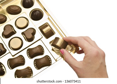 Hand Of A Woman Holding A Chocolate From A Box Of Chocolates.