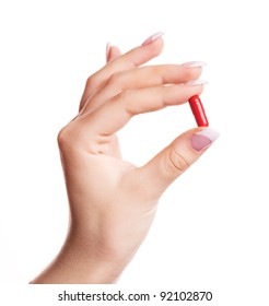 Hand Of A Woman Holding A Pill, Isolated Against White Background