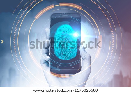Hand of woman holding a smartphone with glowing dactylogram interface and hud over cityscape background. Id and authentication concept. Toned image double exposure copy space
