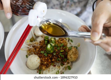 Hand Of Woman Holding Thai Sauce Used As A Condiment,prepared From Fermented Anchovies And Salt,asian Girl Eating Salty Food,pour Fish Sauce In Spoon To Season The Noodle,concept Of Kidney Disease