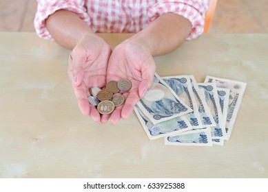 hand woman with Japanese currency yen bank notes and coin.